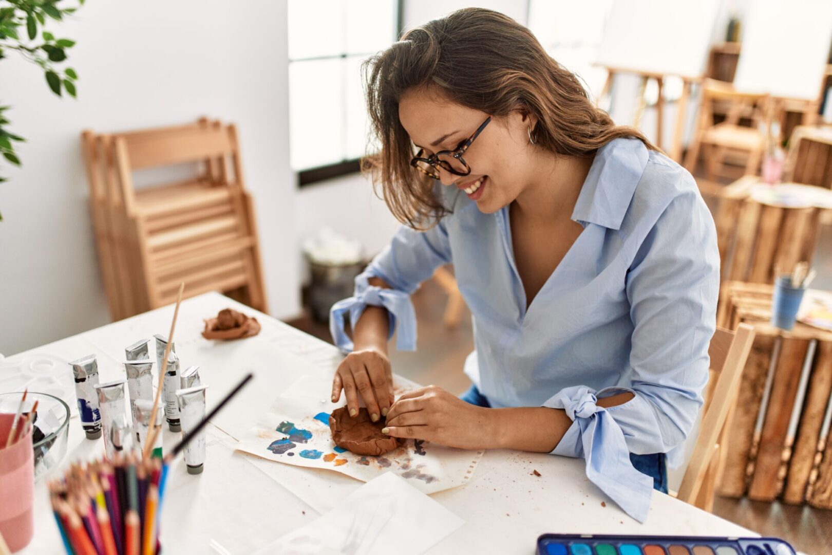 Young beautiful hispanic woman artist smiling confident make ceramic pot with hands at art studio